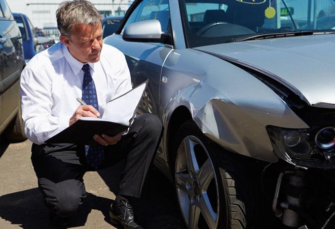 smiling man holding an auto insurance policy